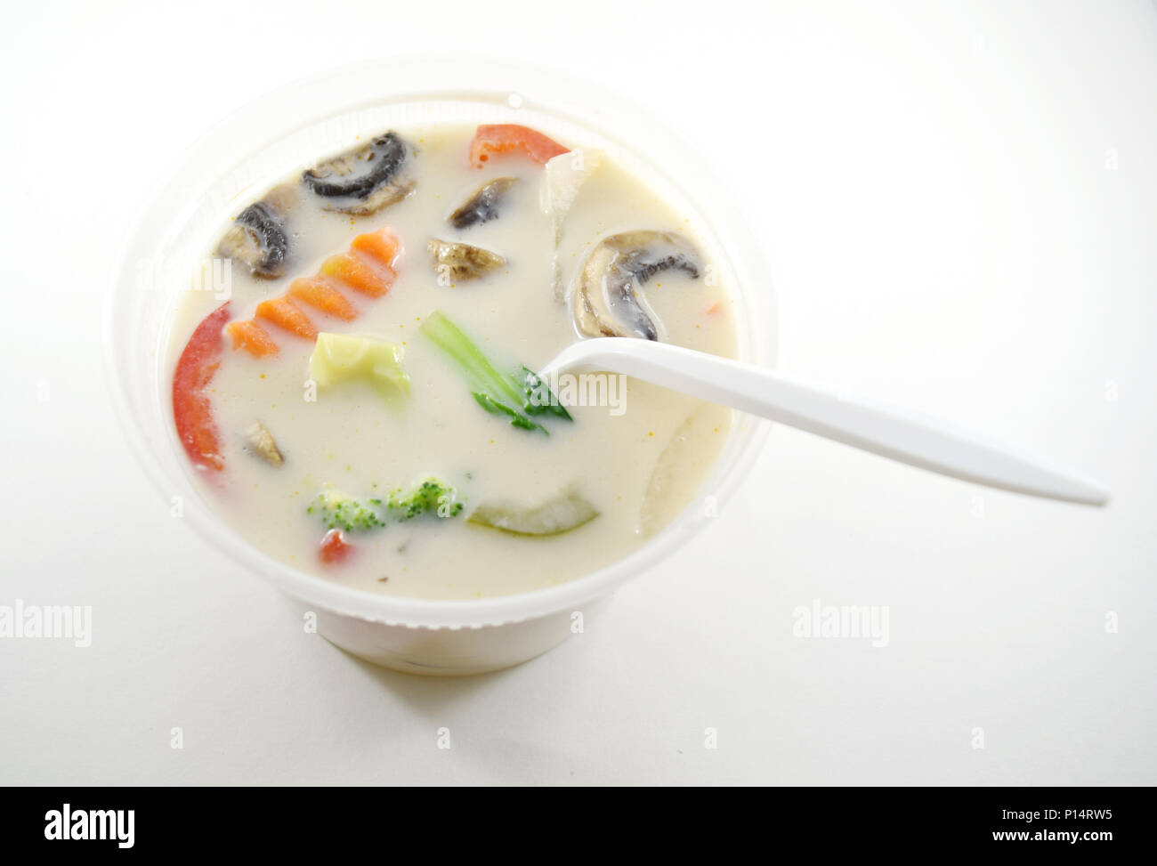 Thai Tom Kha Gai (chicken Kokos Suppe) in Kunststoff takeout Behälter mit Löffel - isoliert Stockfoto