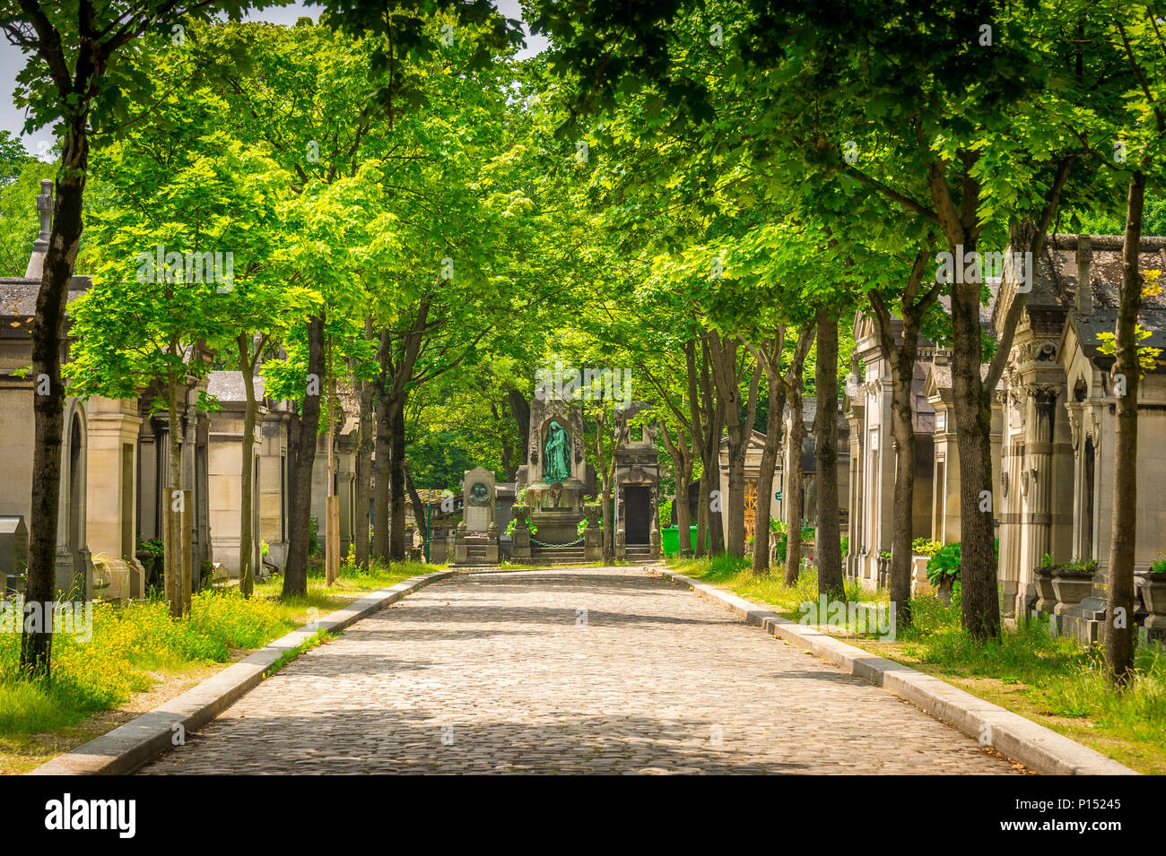 Die breiten, von Bäumen gesäumten Straßen des Friedhofs Père Lachaise sind im Sommer ein idealer Ort für einen Spaziergang. Paris, Frankreich Stockfoto