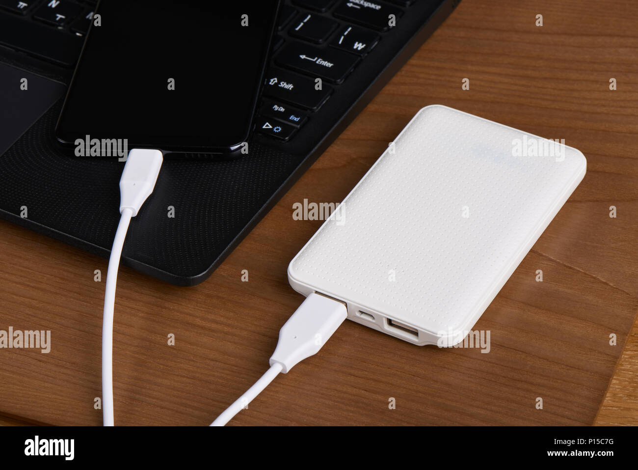 Weiß externe Akku (Power Bank) aufladen Smartphone auf einer hölzernen Hintergrund Stockfoto