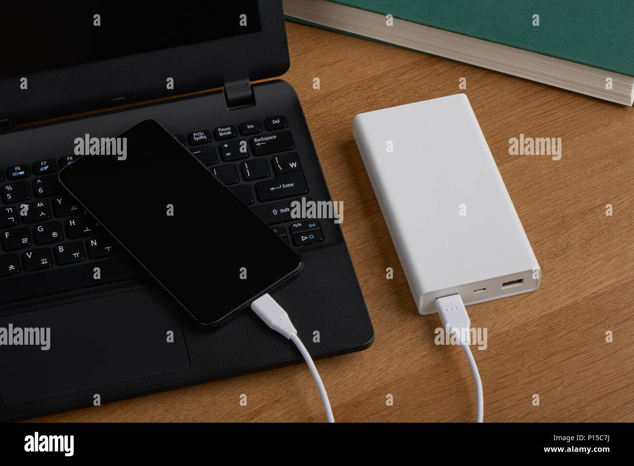 Weiß externe Akku (Power Bank) aufladen Smartphone auf einer hölzernen Hintergrund Stockfoto