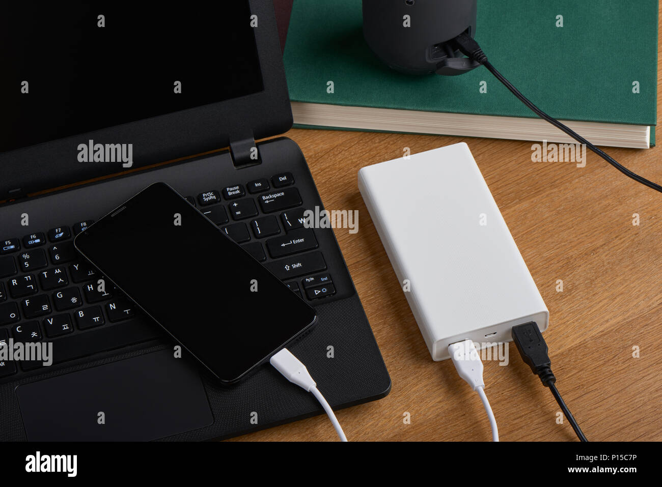 Weiß externe Akku (Power Bank) aufladen Smartphones und drahtlose Lautsprecher auf einem hölzernen Hintergrund Stockfoto