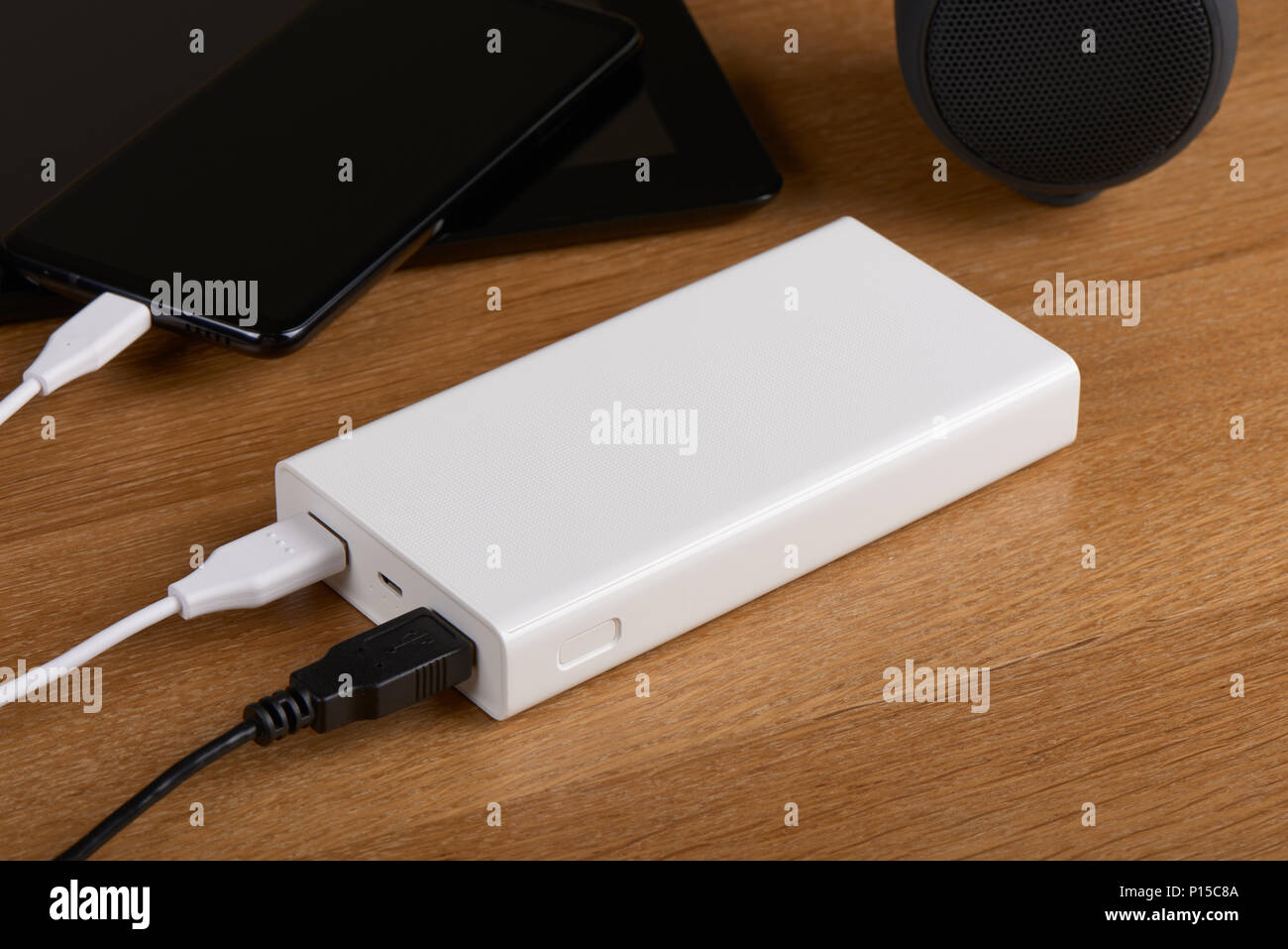 Weiß externe Akku (Power Bank) aufladen Smartphone auf einer hölzernen Hintergrund Stockfoto