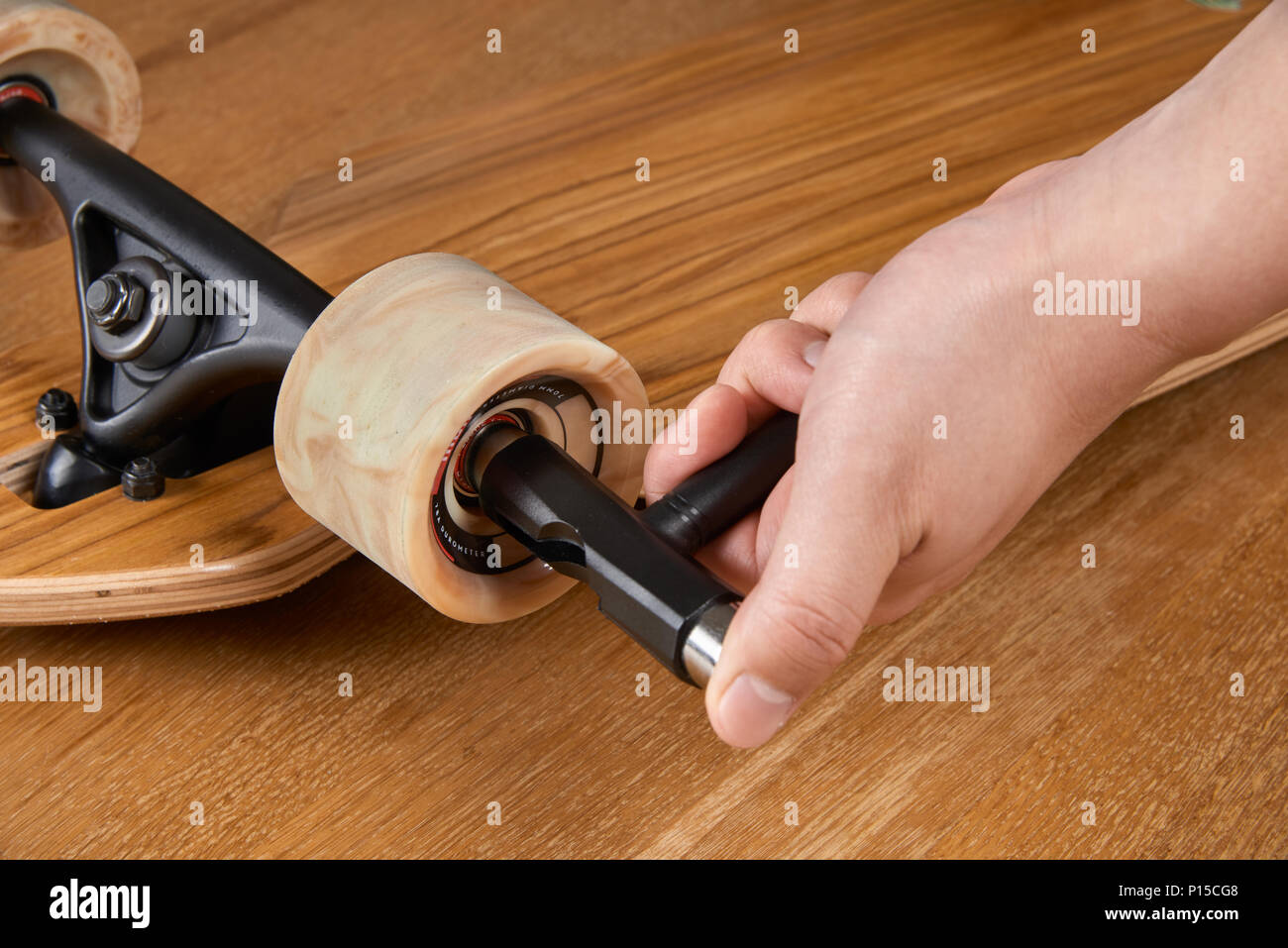 Anziehen der Achsmutter von longboard Truck mit T-Tool Stockfoto