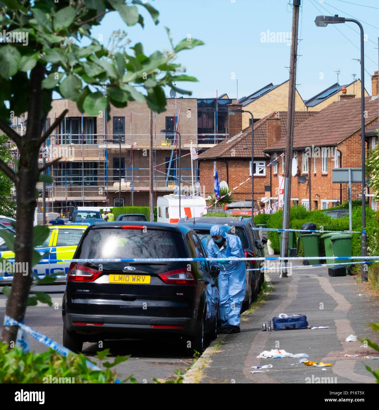 London, England. 11. Juni 2018. Der Morgen, nachdem ein anderer Jugendlicher in London erstochen wird, eine forensische Offizier den Tatort nach Hinweisen in einem Raum durchgeführt werden, die von der Polizei abgesperrt. Dieser stechende, geschah nur kurze Zeit nach dem Mann ein paar Meilen entfernt in Northolt erstochen wurde. © Tim Ring/Alamy leben Nachrichten Stockfoto