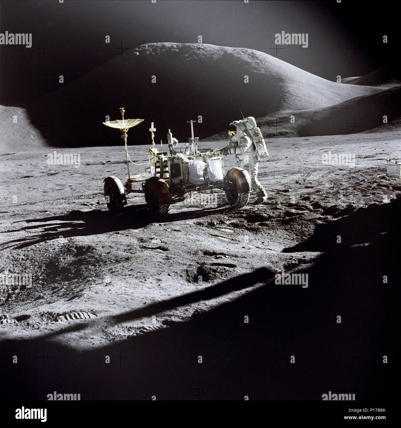 Astronaut James B. Irwin, Lunar Module Pilot, arbeitet bei der Lunar Roving Vehicle während der ersten Apollo 15 Lunar Surface Extra Vehicular Activity (EVA-1) am Hadley-Apennine Landeplatz. Der Schatten der Landefähre "Falcon" im Vordergrund. Diese Ansicht ist nach Nordosten, mit Mount Hadley im Hintergrund. Dieses Photo wurde von Astronauten David R. Scott, Commander. Stockfoto