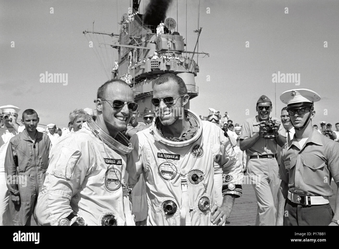 Astronauten L. Gordon Cooper Jr. (rechts) und Charles Conrad jr. zu Fuß über das Deck des Recovery Flugzeugträger U.S.S. Lake Champlain folgenden Splashdown und Wiederherstellung aus dem Ozean. Stockfoto