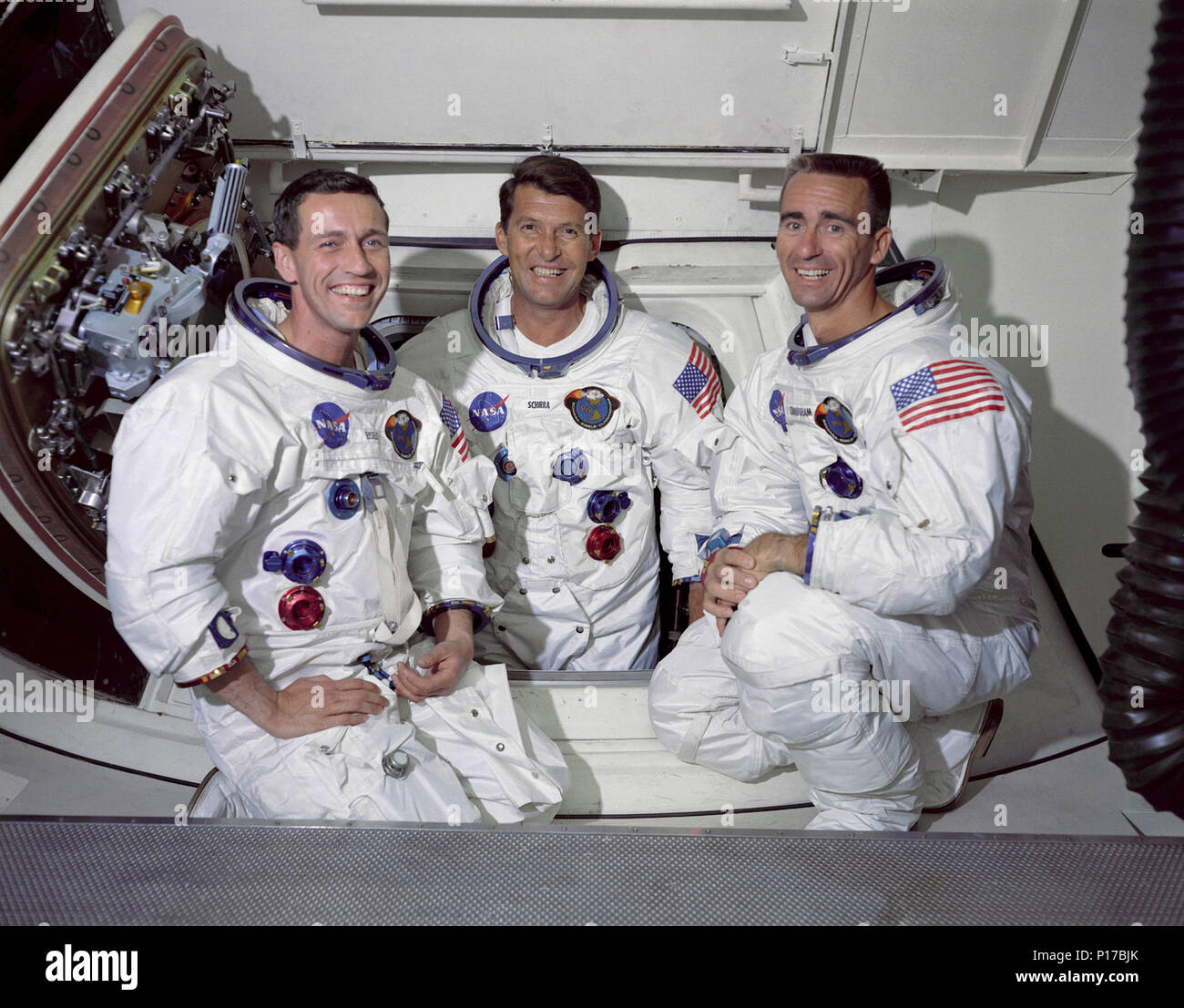 Die Crew der erste bemannte Apollo Space Mission sind von links nach rechts: - Befehl Pilot, Don F. Eisele, Commander, Walter M. Schirra jr. und Lunar Module Pilot, Walter Cunningham. Das Foto wurde im weißen Zimmer, das an die Crew Arm befestigt ist. Von hier aus Astronauten Ingress- und das Raumschiff. Commander Wally Schirra Jr. ist in der Öffnung der Luke der Command Modul gesehen. Stockfoto