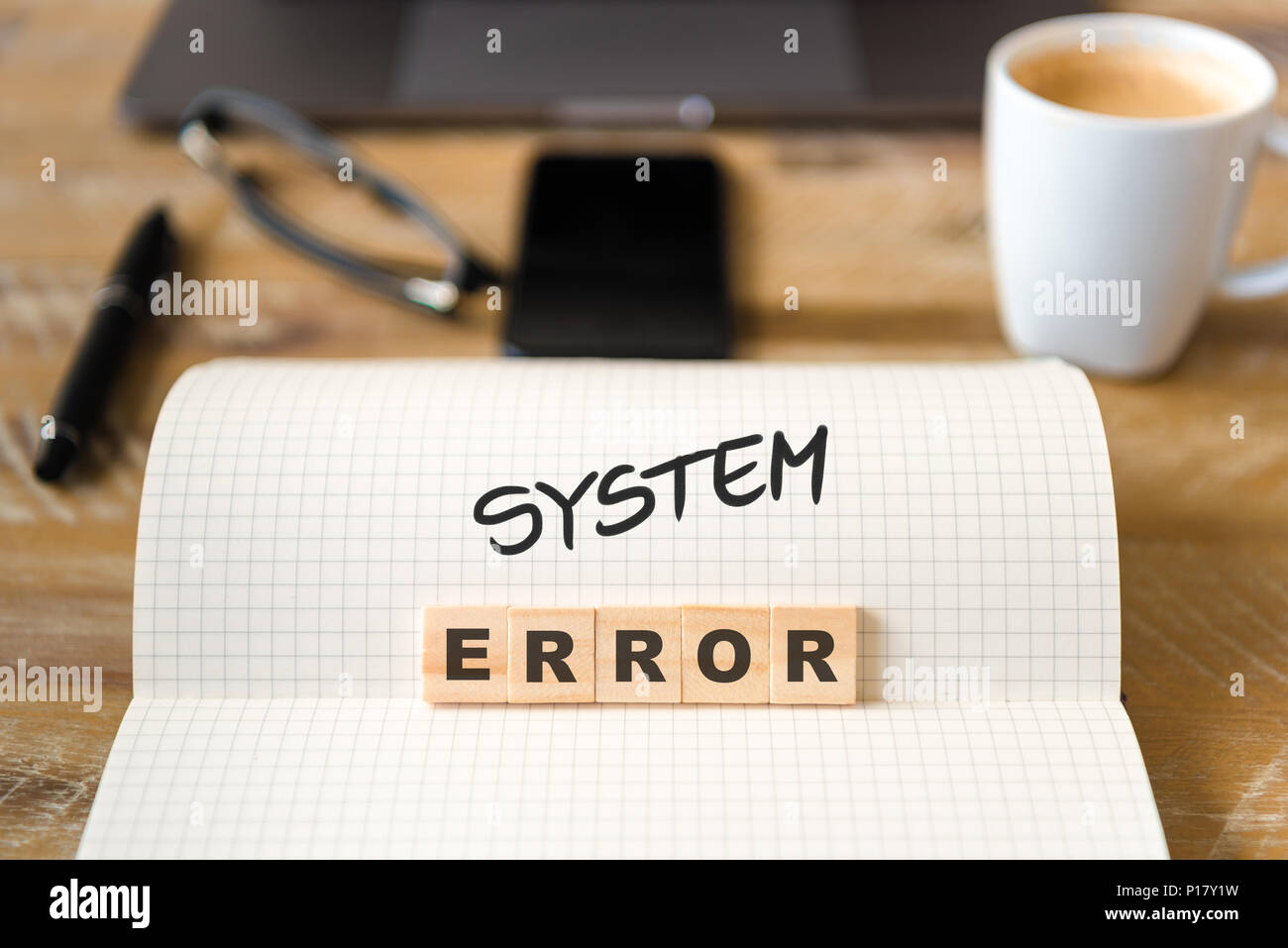 Nahaufnahme auf das Notebook um Vintage Schreibtisch Oberfläche, front Fokus auf Holzblöcke mit Buchstaben, System Error text. Stockfoto