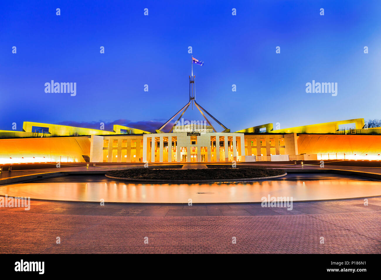 Wasser Pool vor neuen Parliament House in Canberra auf dem Capitol Hill bei Sonnenuntergang reflektieren helle Beleuchtung in fliessend Wasser. Stockfoto