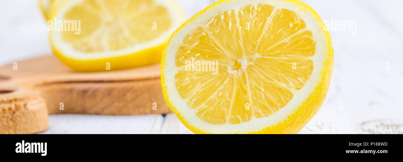 Ein Becherglas und einen Krug kalten Limonade auf einem weißen Hintergrund Holz umgeben von Zitronen Stockfoto