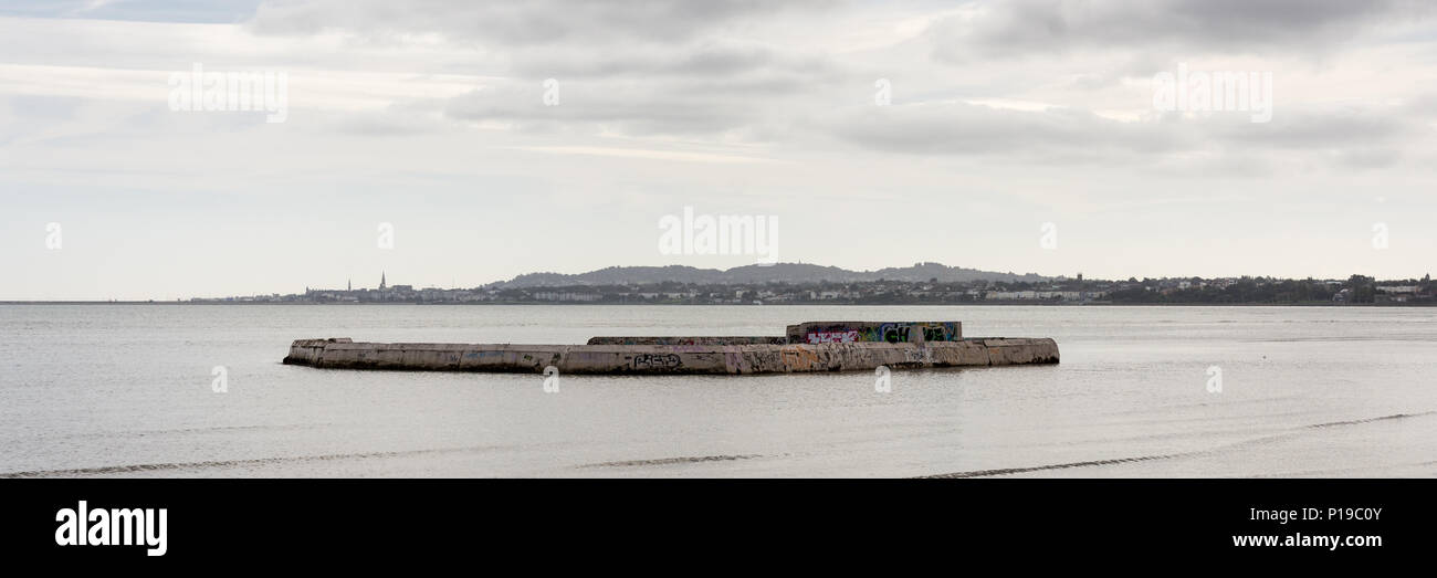 Der marode und stillgelegten Merrion Bäder konkrete Lido auf Sandymount Strand in der Bucht von Dublin, mit Dun Laoghaire in der Ferne. Stockfoto