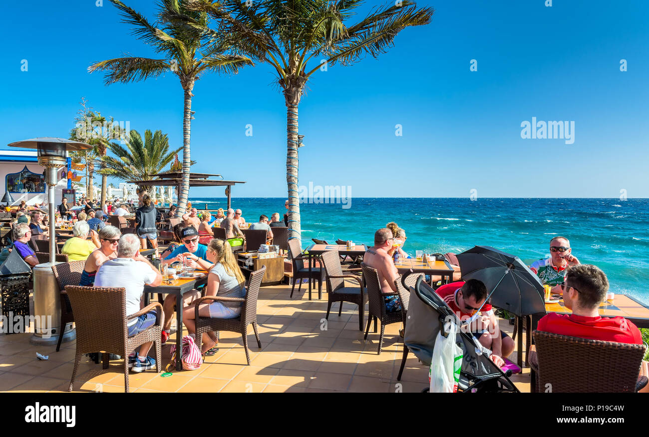 Puerto del Carmen, Spanien - 29. Dezember 2016: Touristen genießen Getränke und Landschaft im Café La Ola in Puerto del Carmen, Spanien. Puerto del Carmen ist der m Stockfoto