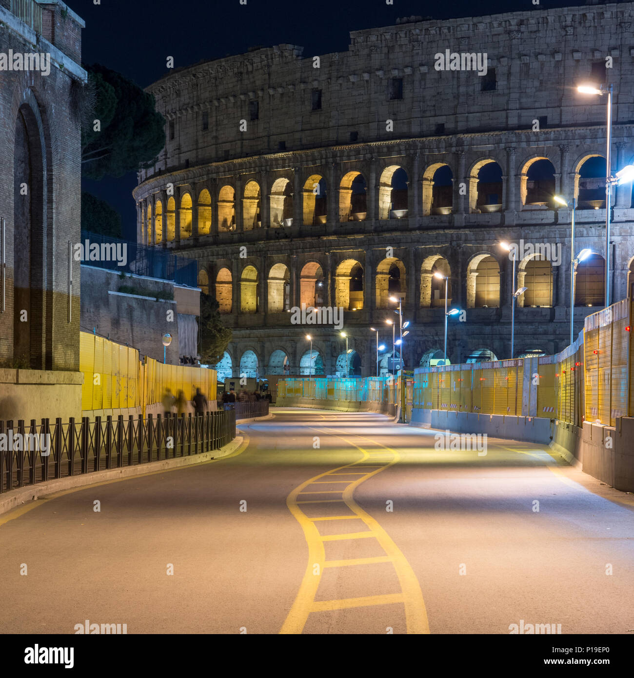 Rom, Italien, 25. März 2018: Die römischen Kolosseum steigt hinter die Bauarbeiten für die U-Bahn Linie C auf die Via dei Fori Imperiali in der Nacht. Stockfoto