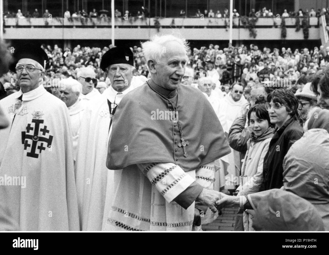 KARDINAL BASIL HUME SPAZIERT BEI DER MESSE ZUM 100. JAHRESTAG DER KATHOLISCHEN KIRCHE AUF DEM GUILDHALL-PLATZ IN PORTSMOUTH UNTER DEN MASSEN. 1983 Stockfoto