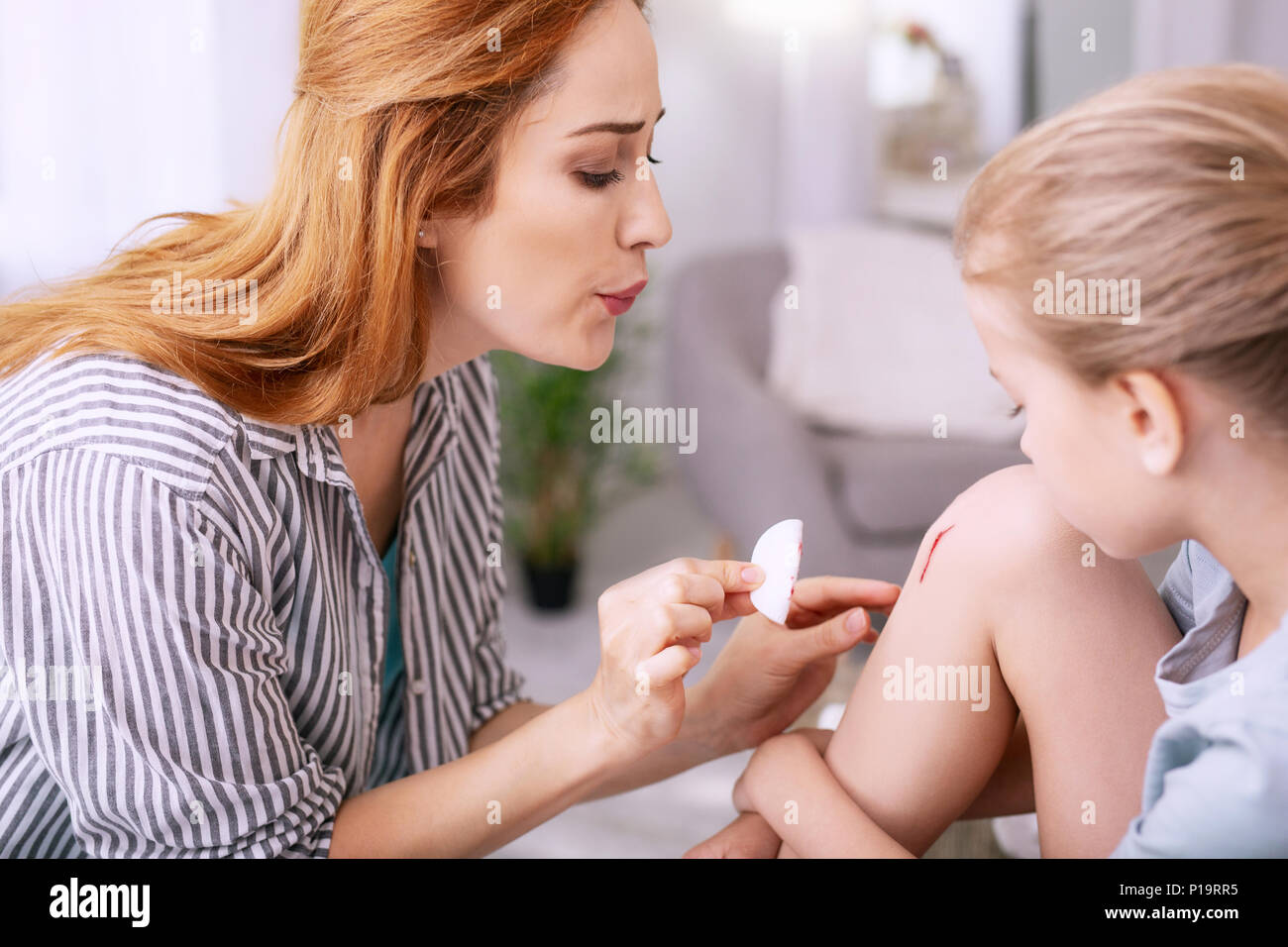 Nette gut aussehende Frau, die ihr Kind helfen Stockfoto