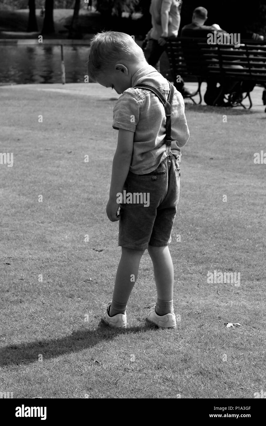 Junge allein in Shorts schwarz/weiß Foto stehend Stockfoto