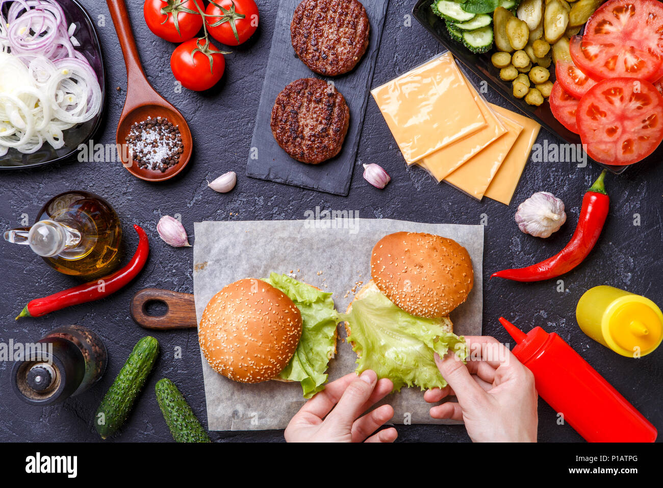 Foto oben von zwei Hamburger, menschliche Hände und Zutaten Stockfoto