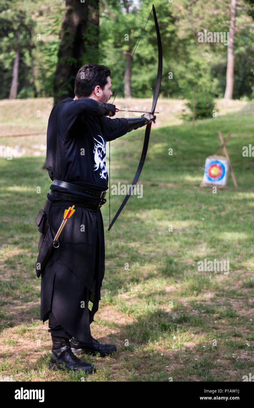 Nis, Serbien - 10. Juni 2018: Mittelalterliche Archer mit großen holzbogen und lange Pfeil in Wald. Lebendige Geschichte Festival. Bogenschießen Turnier Stockfoto