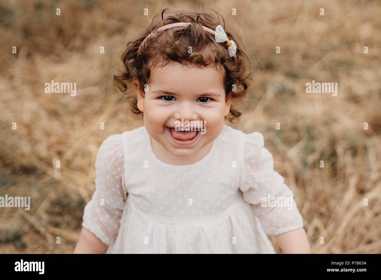 Süßes kleinkind Mädchen stehen auf Wiese mit schönen Lächeln. Stockfoto
