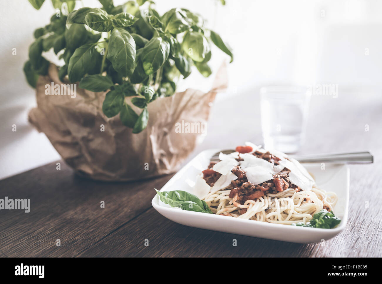 Nahaufnahme der Pasta mit Sauce Bolognese, Basilikum und Parmesan auf rustikalen Holztisch Stockfoto