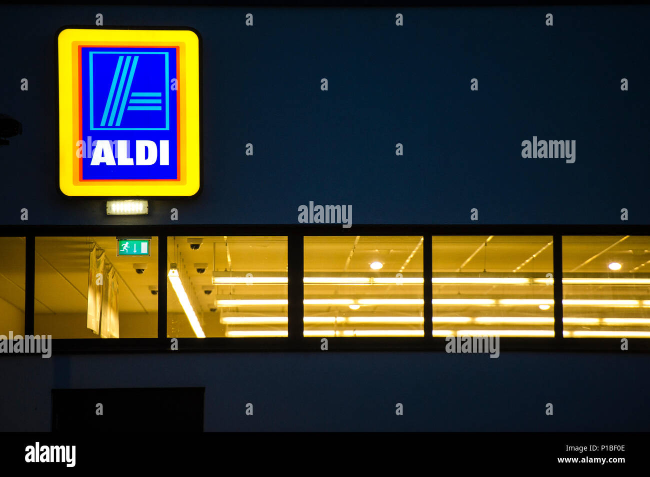 Aldi Discounter beleuchtete Logo Zeichen, Außen, Nacht, Cirencester England Großbritannien Stockfoto