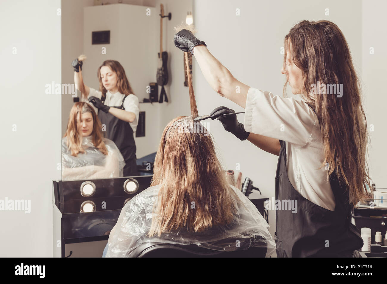 Weibliche Stilist, ein Farbstoff an die Clients Haare Beauty Salon Stockfoto