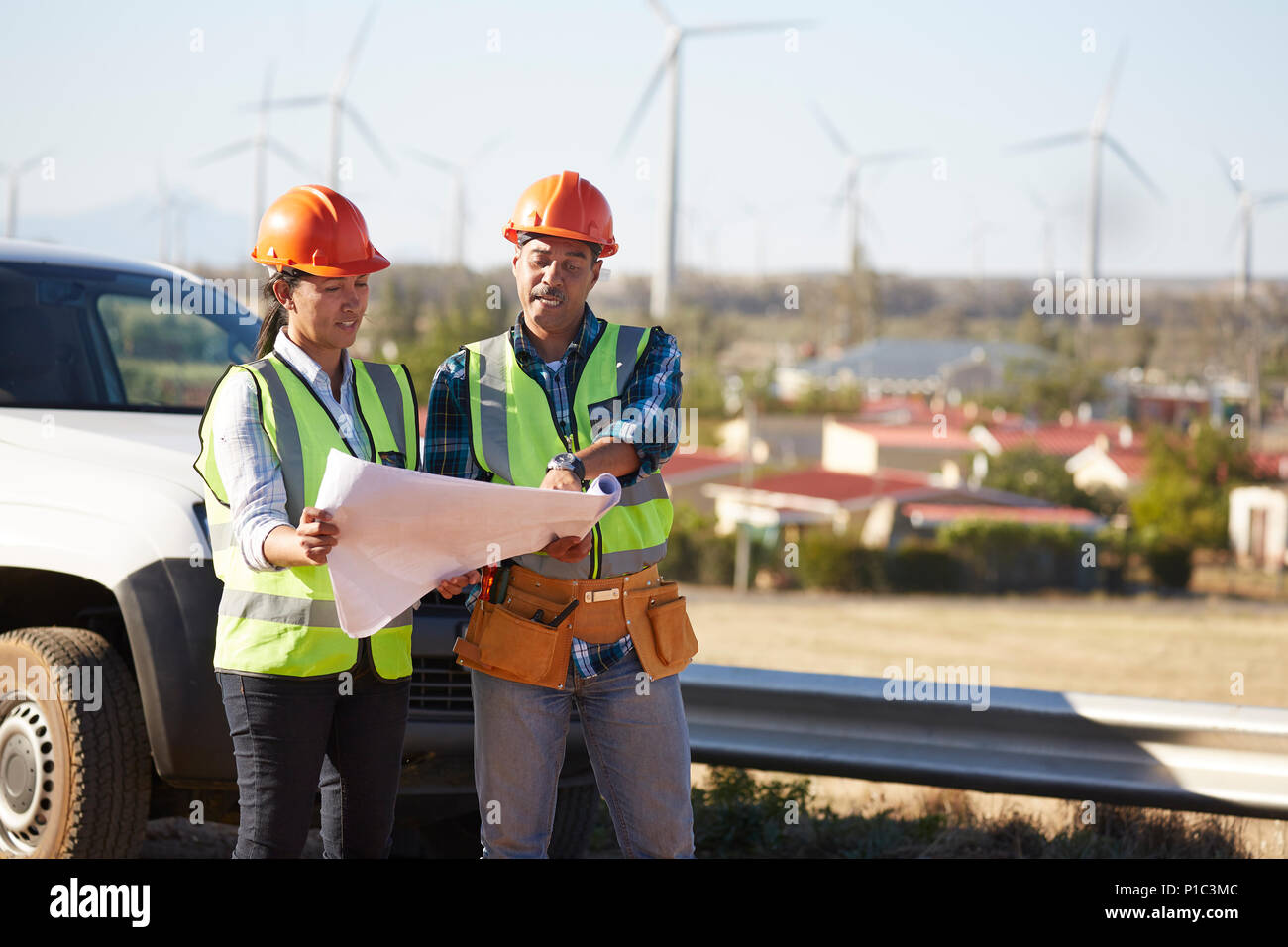 Ingenieure überprüfen von Plänen in der Nähe der Windenergieanlage Farm Stockfoto