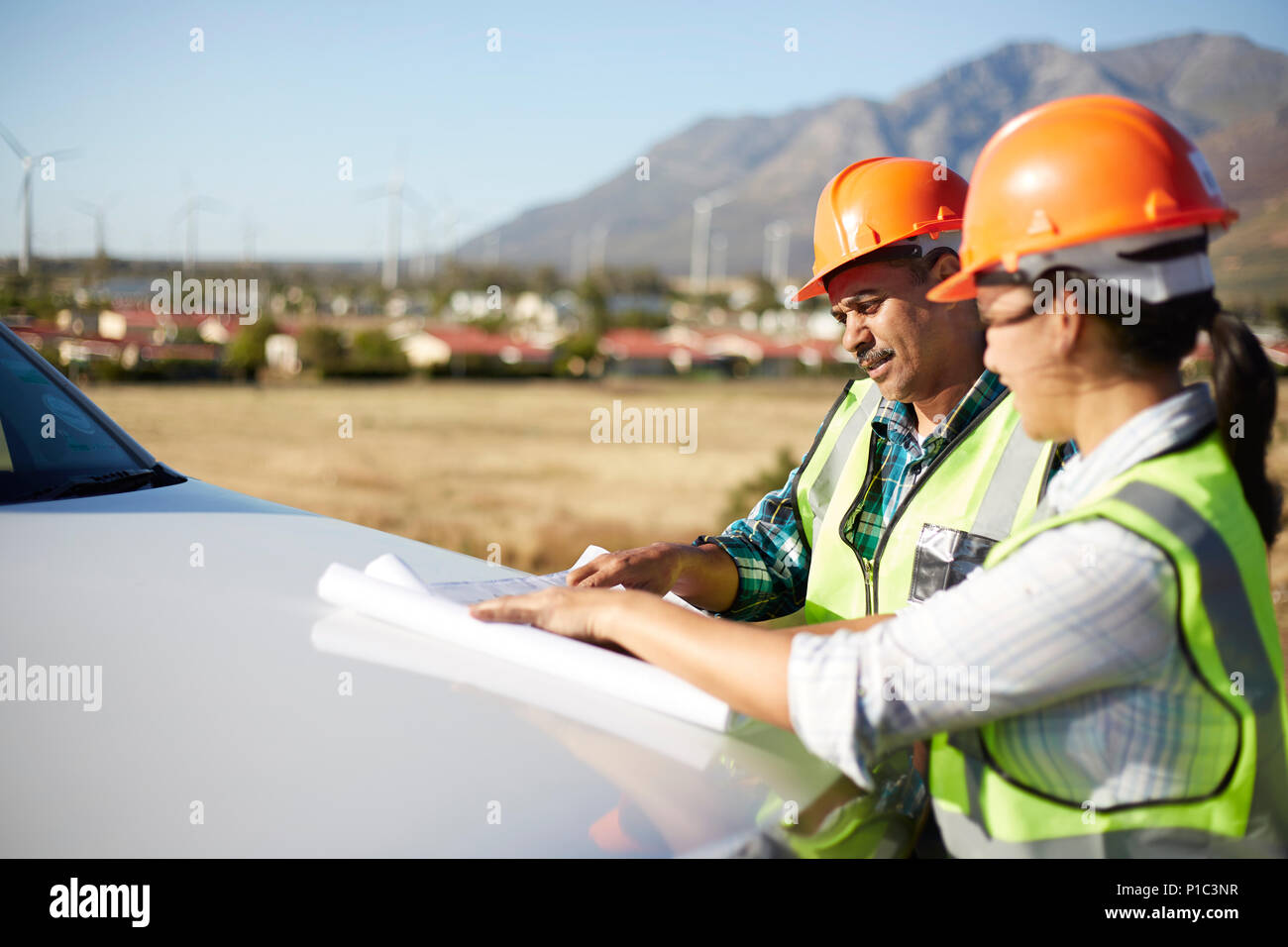 Ingenieure überprüfen Blueprints auf Lkw am sonnigen Kraftwerk Stockfoto