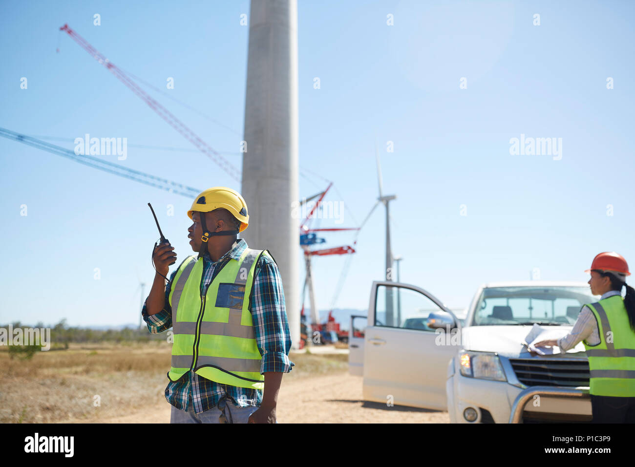 Männliche Ingenieur mit walkie-talkie am sonnigen Windenergieanlage Kraftwerk Stockfoto