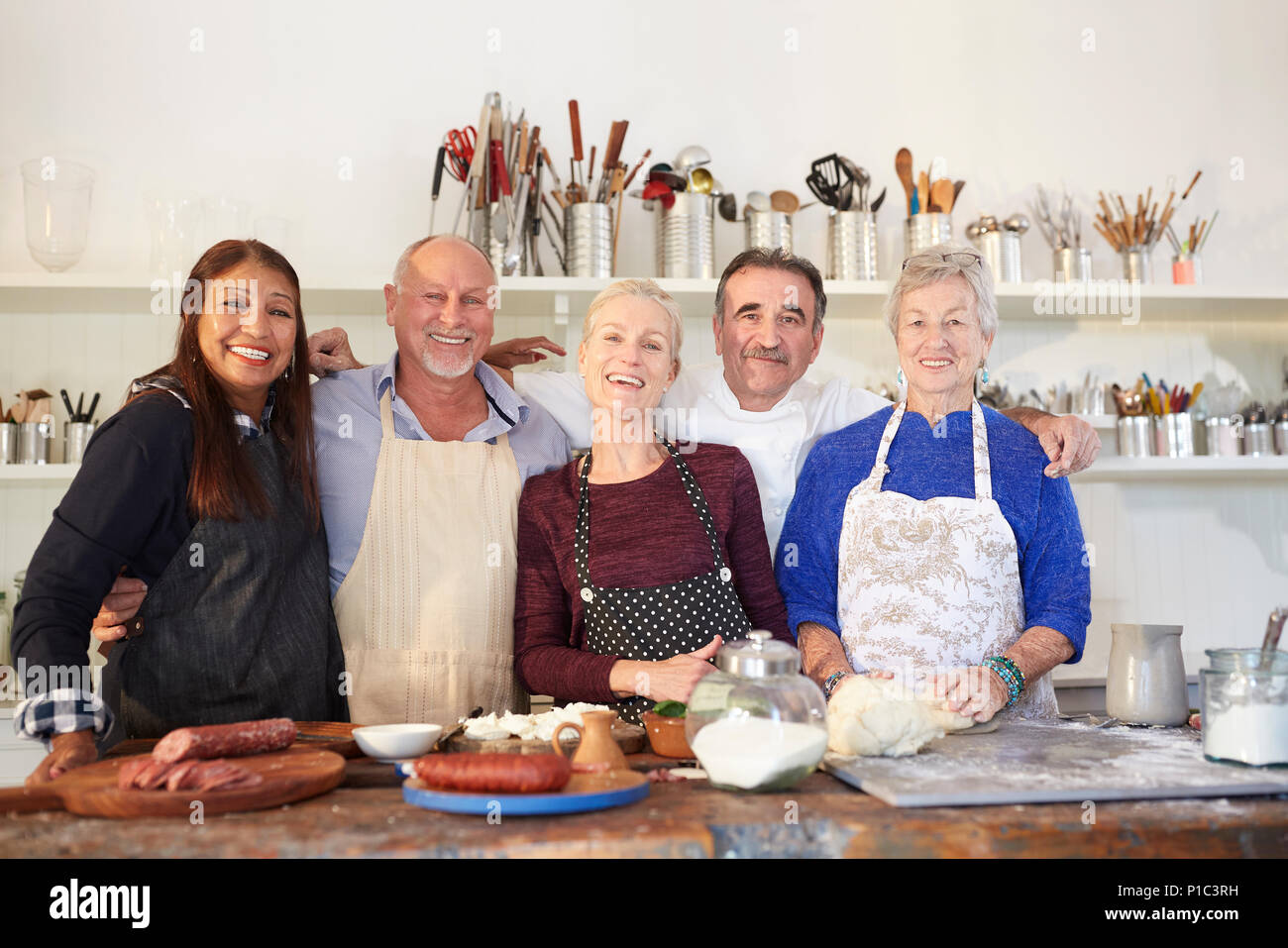 Portrait glückliche, selbstbewusste ältere Freunde und Küchenchef in Pizza Kochkurs Stockfoto
