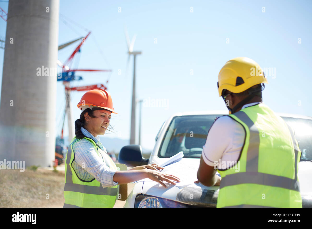 Ingenieure überprüfen Blueprints auf Lkw am sonnig wind turbine Kraftwerk Stockfoto