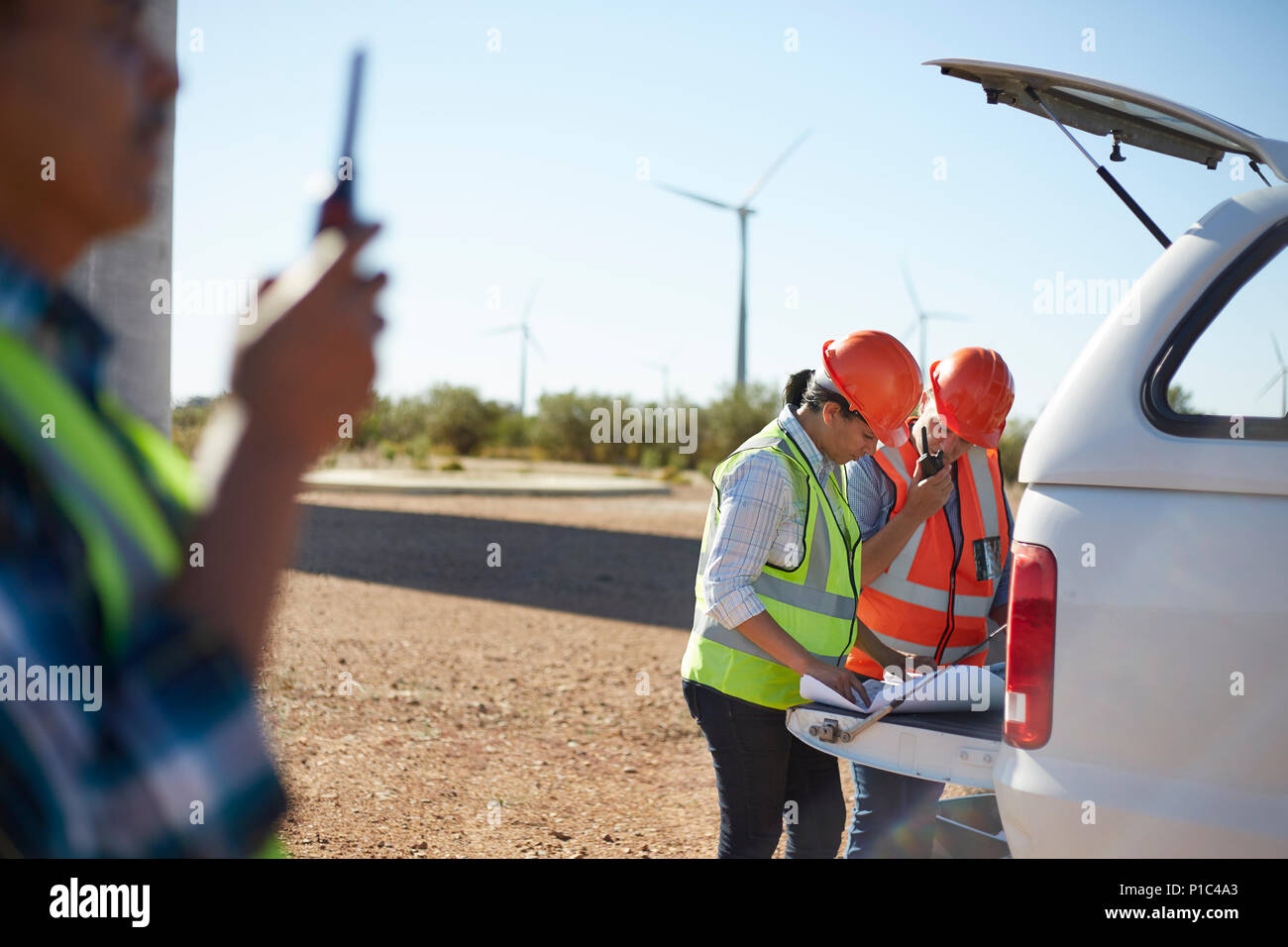 Ingenieure überprüfen Blueprints auf Lkw am sonnig wind turbine Kraftwerk Stockfoto