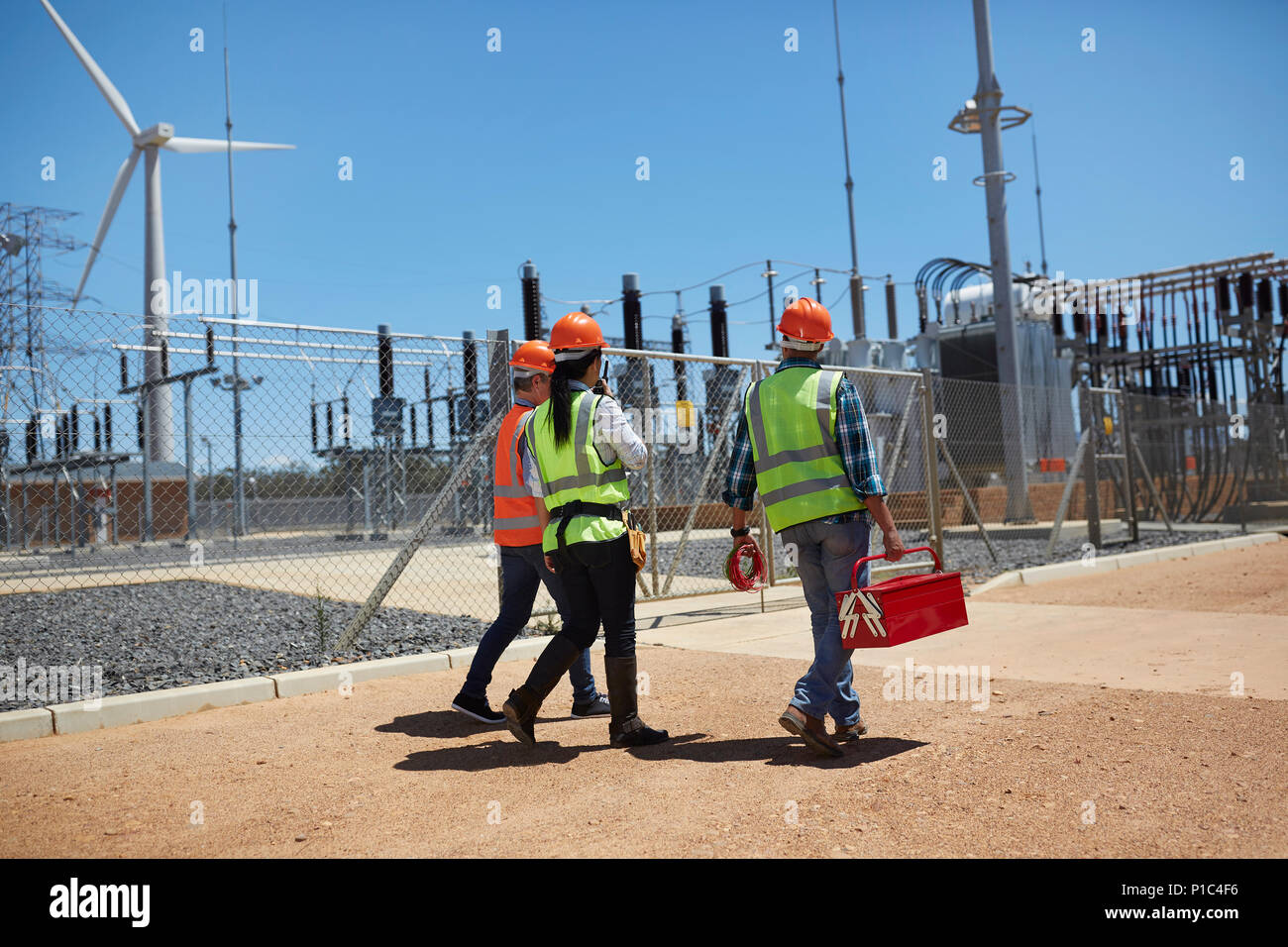 Ingenieure mit Toolbox gehen an sonnigen Windenergieanlage Kraftwerk Stockfoto