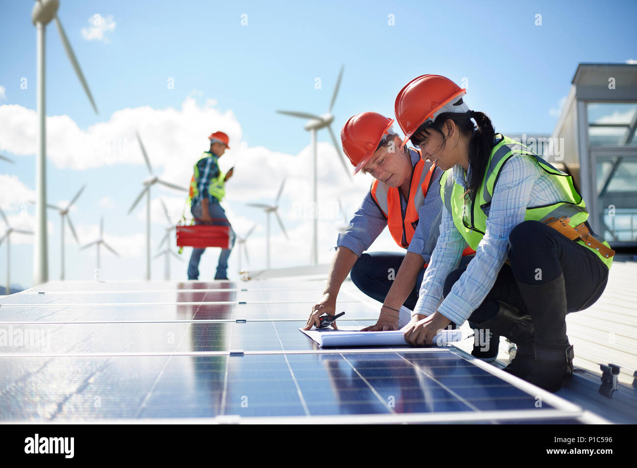 Ingenieure überprüfen Blueprints auf solar panel an Kraftwerk Stockfoto