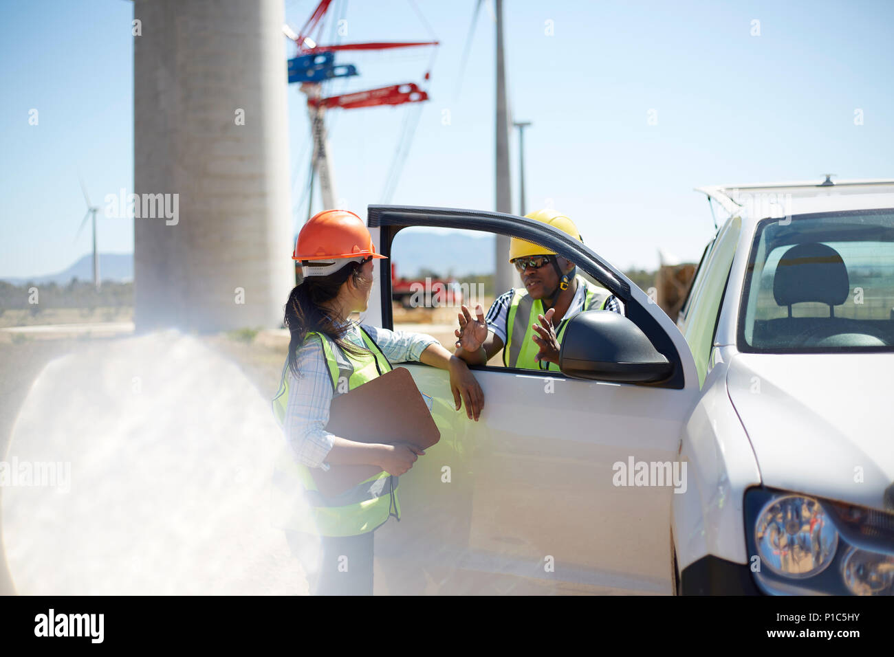 Arbeitnehmer sprechen bei Fahrzeug im Kraftwerk Stockfoto