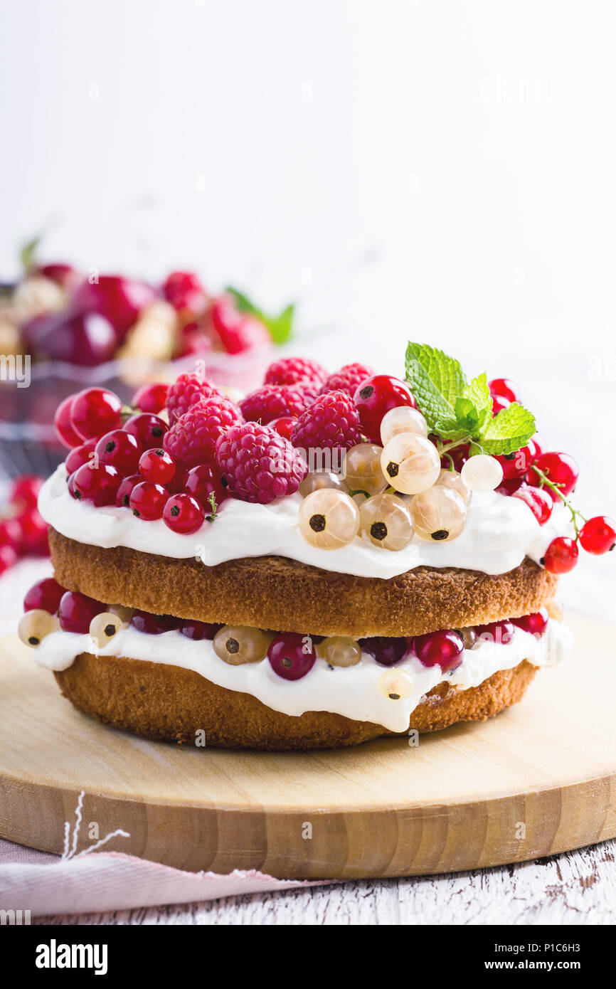 Torte mit Frischkäse und frische Beeren auf rustikalen Holzbrett Stockfoto
