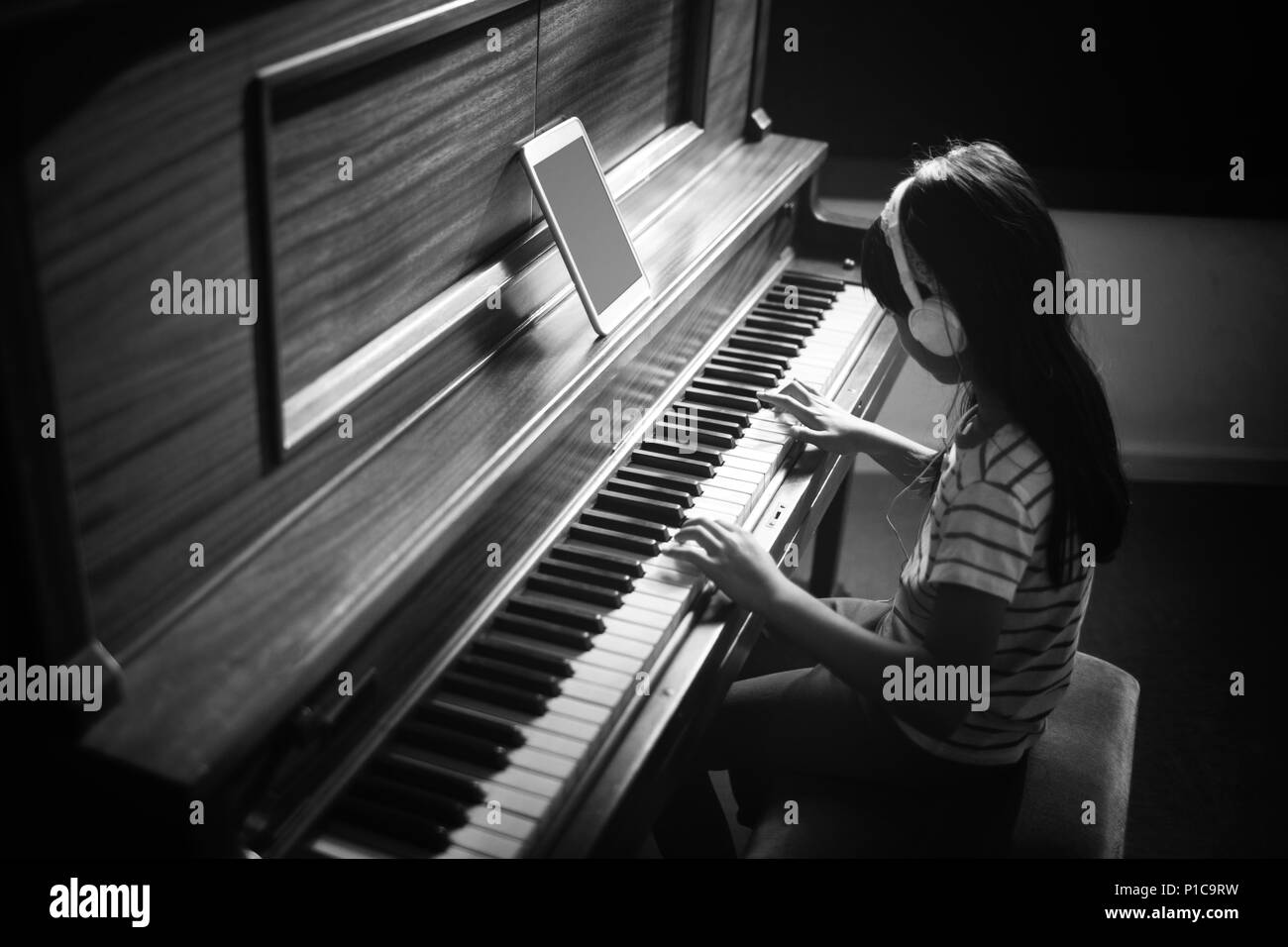 Hohe Betrachtungswinkel von konzentriertem Mädchen üben Klavier Stockfoto