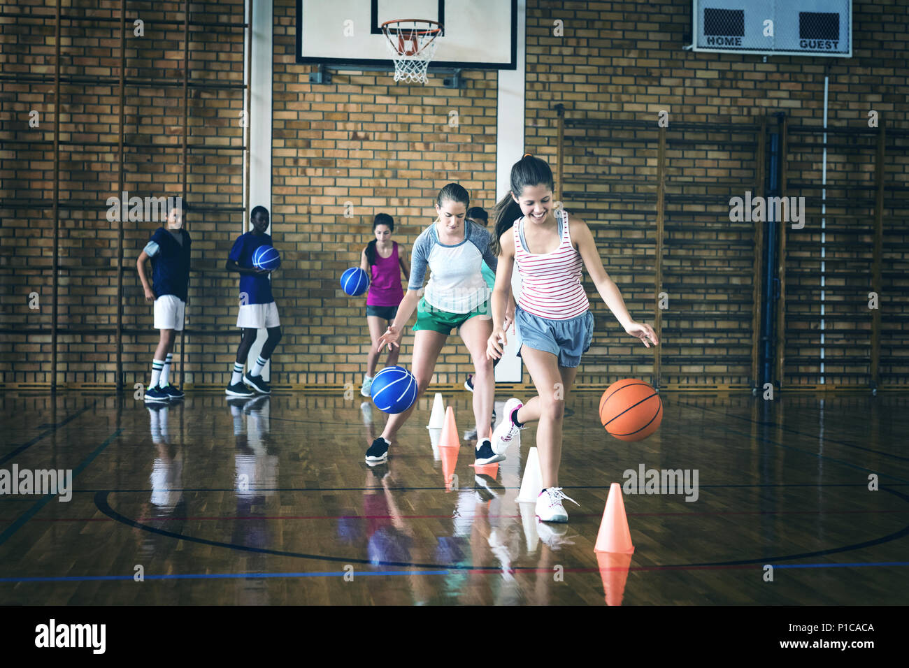 High School Kids üben Fußball mit Kegel für Dribbling bohren Stockfoto