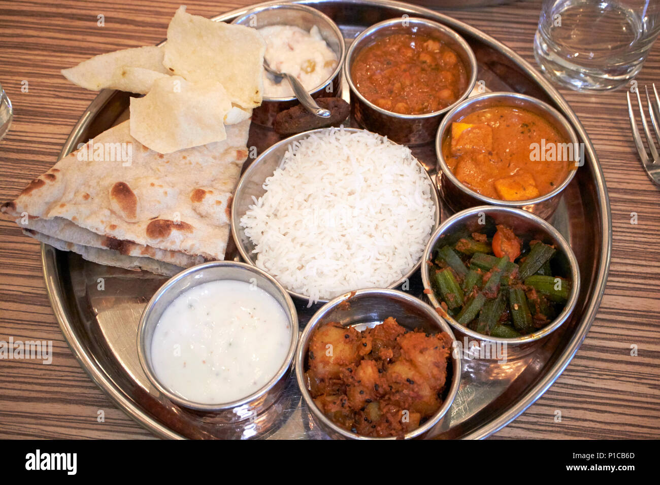 North Indian grand Thali meal einschließlich Papadums paneer Butter masala Raita naan Reis und Dessert vegetarische Mahlzeit in England UK Stockfoto
