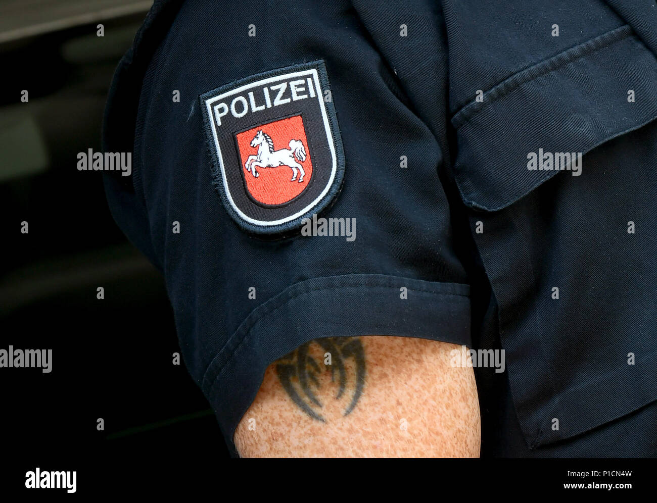 5. Juni 2018, Hannover, Deutschland: Der Polizist Enrico Burtz präsentiert eine Tätowierung auf dem Oberarm. Es sind nur sichtbar, wenn der kurze Ärmel seiner Uniform nach oben rutschen. Foto: Holger Hollemann/dpa Stockfoto
