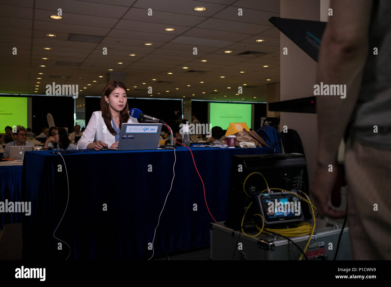 Eine Nachrichten Anker während einer Live-Übertragung aus dem Singapur Media Center. Die Nordkoreanische "DVRK" Führer Kim Jong Un und US-Präsident Donald Trump veranstaltete ein Gipfel in Singapur, die beide Parteien zum Ausdruck, dass das Treffen war erfolgreich und konstruktiv. Stockfoto