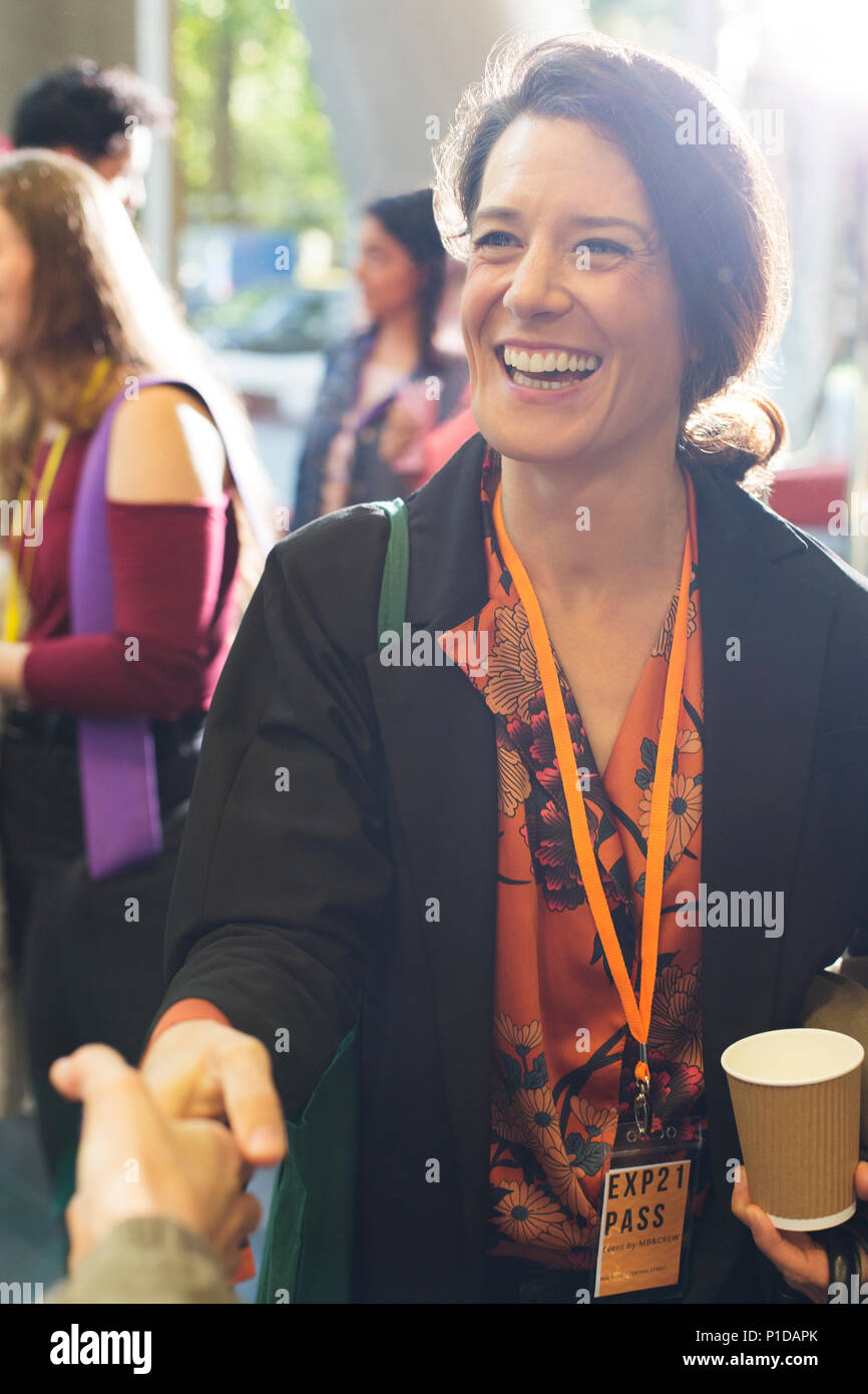 Lächelnd, enthusiastisch Geschäftsfrau Händeschütteln mit Kollegen an der Konferenz Stockfoto