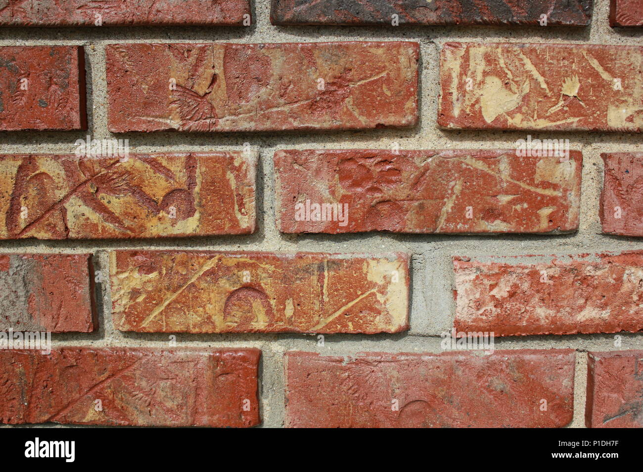 Nahaufnahme einer typischen gemeinen Ziegelmauer bei strahlendem Sonnenschein. Stockfoto
