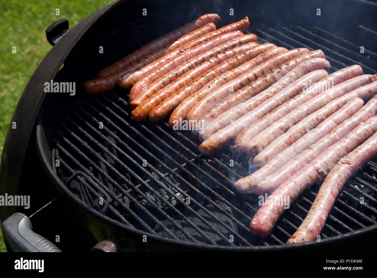 Grill: Eine Auswahl von Würstchen kochen auf einem Holzkohlegrill Stockfoto
