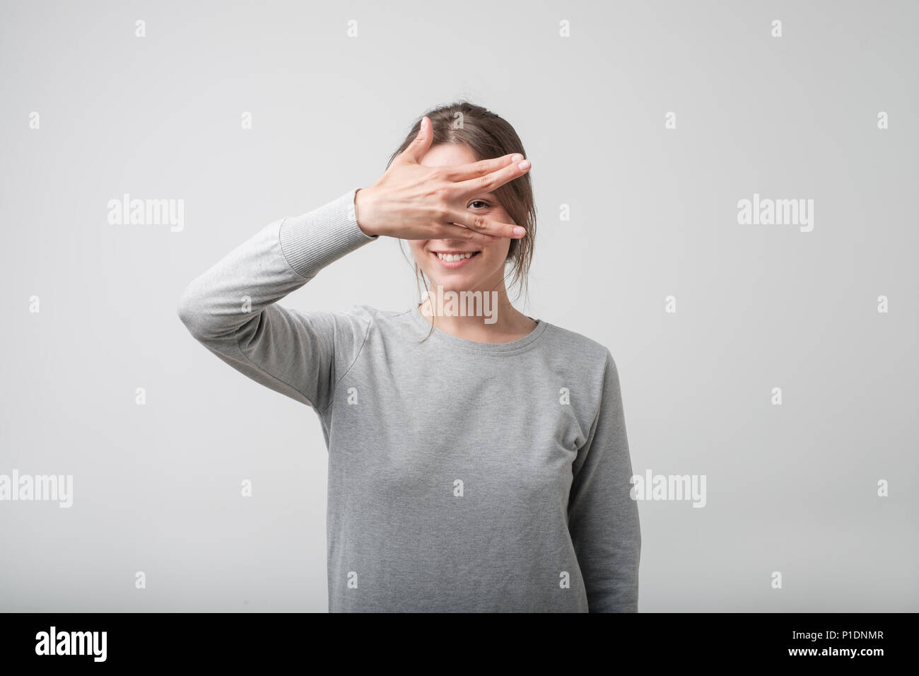 Junge glücklich Europäische Weiblich mit Händen über ihr Gesicht. Stockfoto