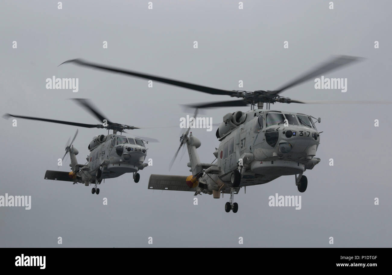 Japanische UH-60 J Hubschrauber verlassen in simulierten Unfall Evakuierungen während eine amphibische Kriegsführung übung auf der DDH Typ Hyuga zu helfen und zugleich in den Pazifischen Ozean, 19. Mai 2018 im Gange. Marinesoldaten und Matrosen mit Combat Logistik Bataillon 31, 31 Marine Expeditionary Unit, verband die Japan Masse Verteidigung-kraft service Mitglieder mit der neu gebildeten amphibischen Rapid Deployment Brigade zu begeben, um die Funktionalität der ARDB mit verschiedenen Situationen auf den Inseln zu verbessern. Die 31. MEU, das Marine Corps' nur kontinuierlich vorwärts - bereitgestellt MEU, bietet eine flexible Kraft bereit, ein durchführen Stockfoto