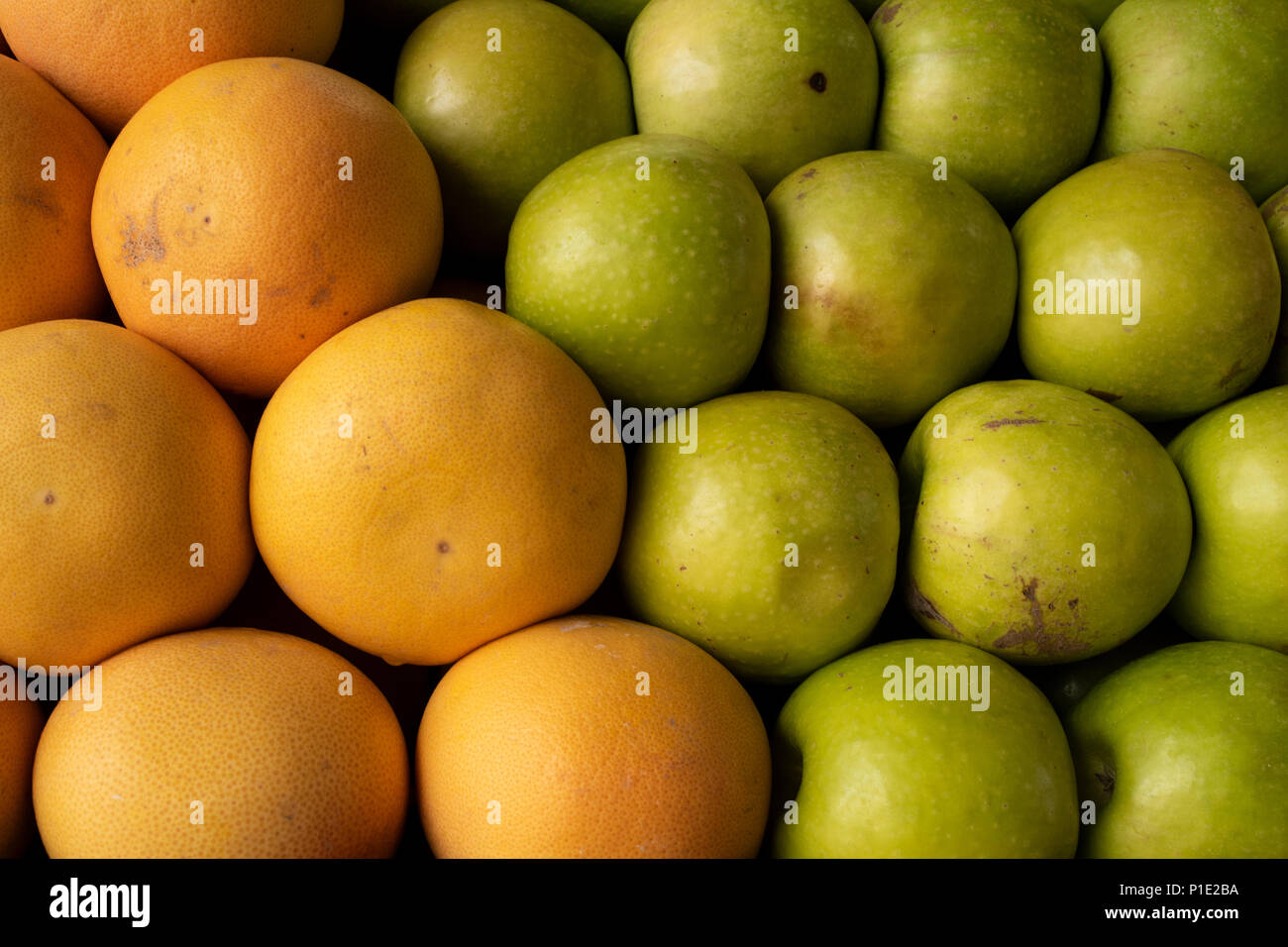 Riesige Orangen in einem hellen Dick schälen und grünen Äpfeln. Stockfoto