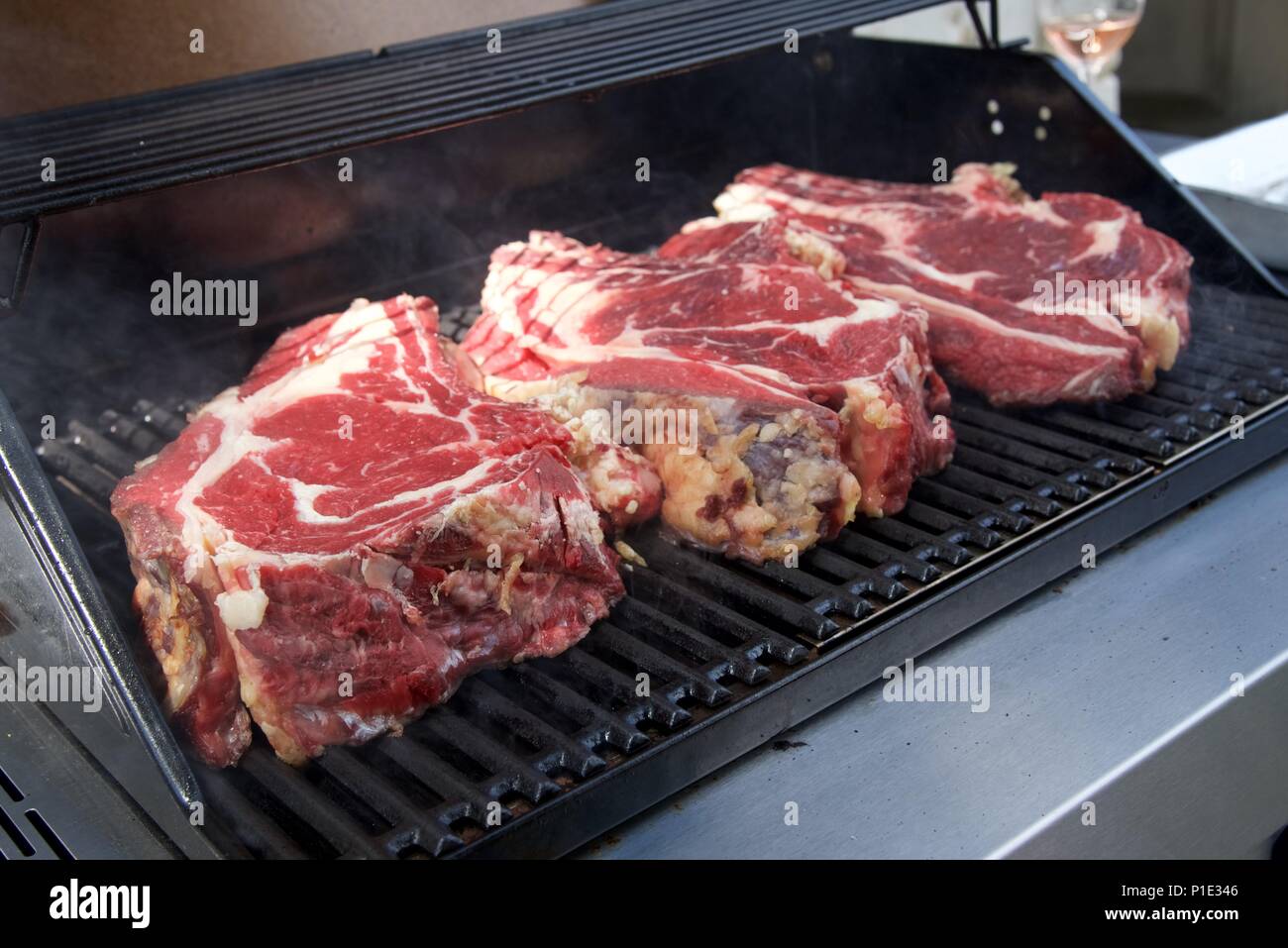 Grill: Drei große Teilstücke von Rindfleisch aus Frankreich (Côte de Boeuf  à l'Os) auf einen Gasgrill Stockfotografie - Alamy