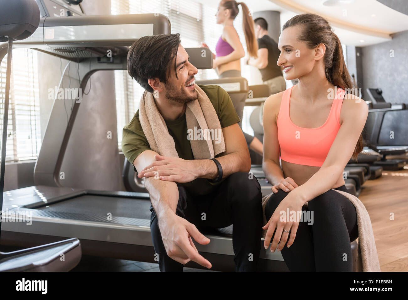 Fröhlicher junger Mann und Frau trinkt Wasser während der Pause Stockfoto