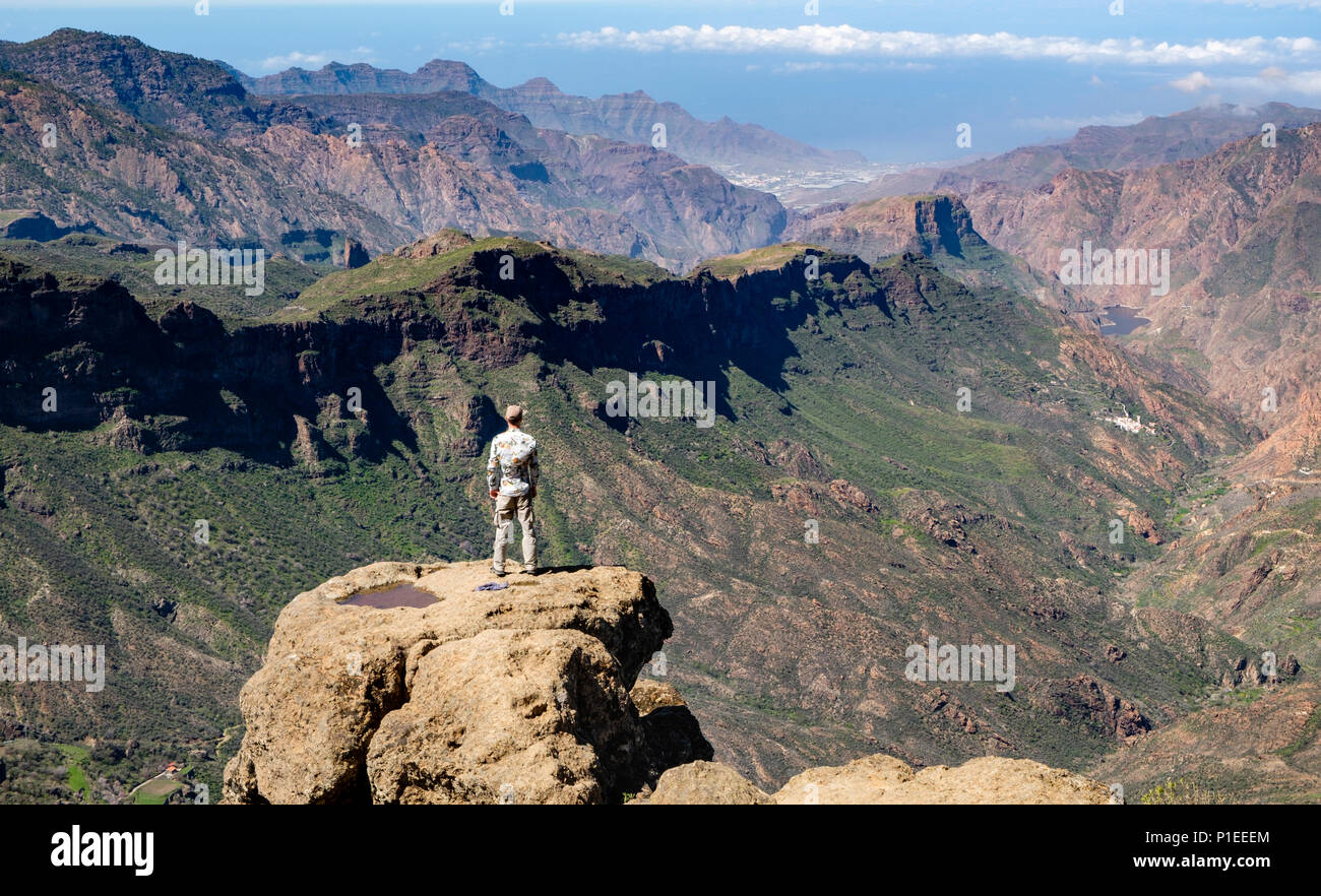 Mann sieht von Roque Nublo über die bergige Land von Gran Canaria, Gran Canaria, Kanarische Inseln, Spanien Stockfoto